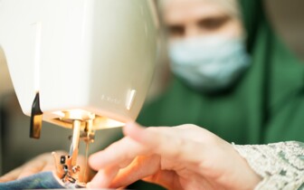 Frau mit Kopftuch im Integrationshaus an der Nähmaschine